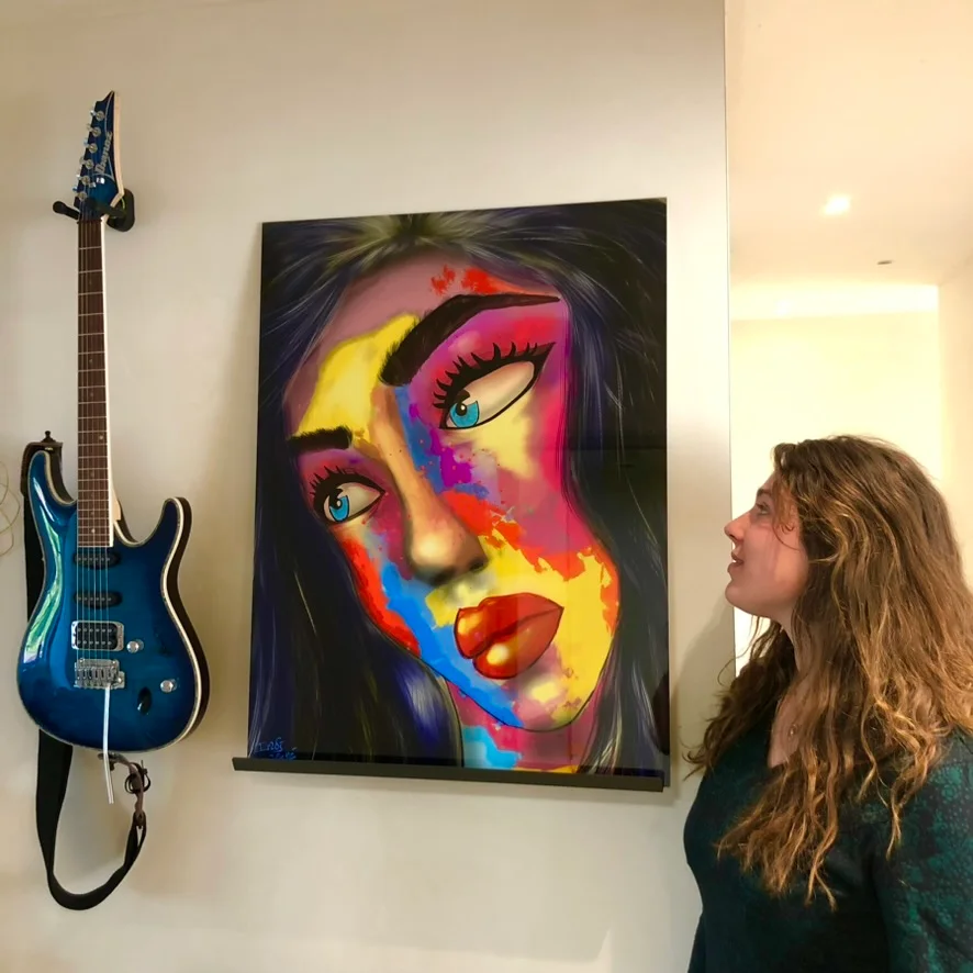 Indi next to her large, colourful painted portrait