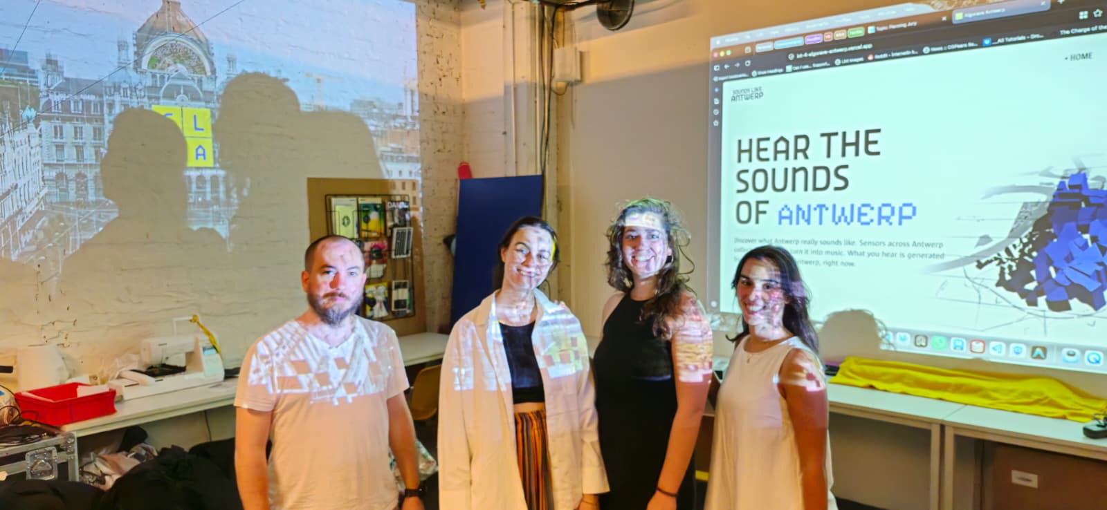The four team members in front of the projected Sounds Like Antwerp website